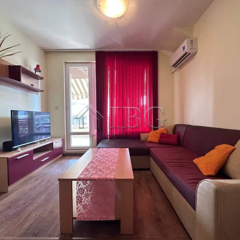Bright living room with sofa, TV, and balcony in Ravda apartment.