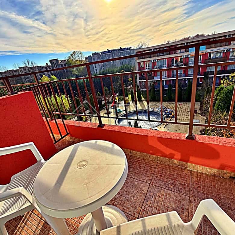 Pool view balcony with chairs and table at Orchid Fort Club, Sunny Beach.