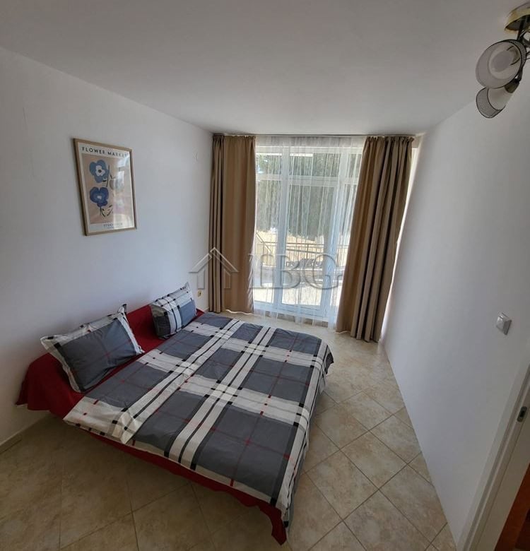 Bright bedroom with garden view and access, featuring a comfortable bed and natural light.