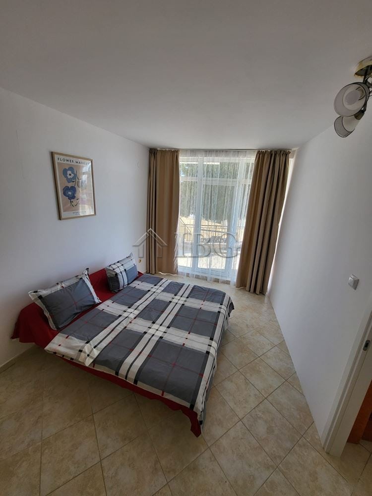 Bright bedroom with garden view and access, featuring a comfortable bed and natural light.