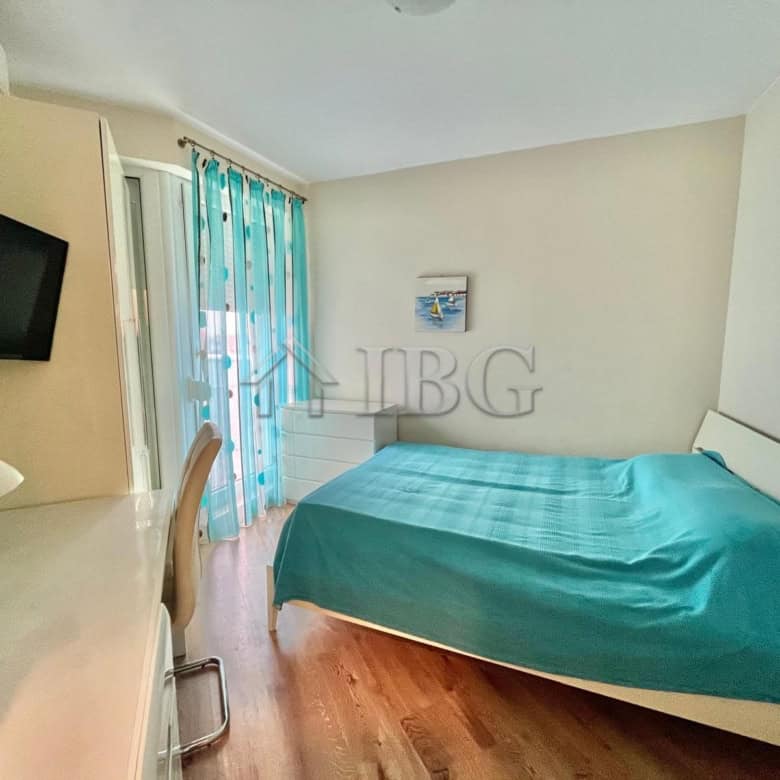 Cozy bedroom featuring a large bed, sea view, and balcony access in Ravda, Bulgaria. Perfect for rel.