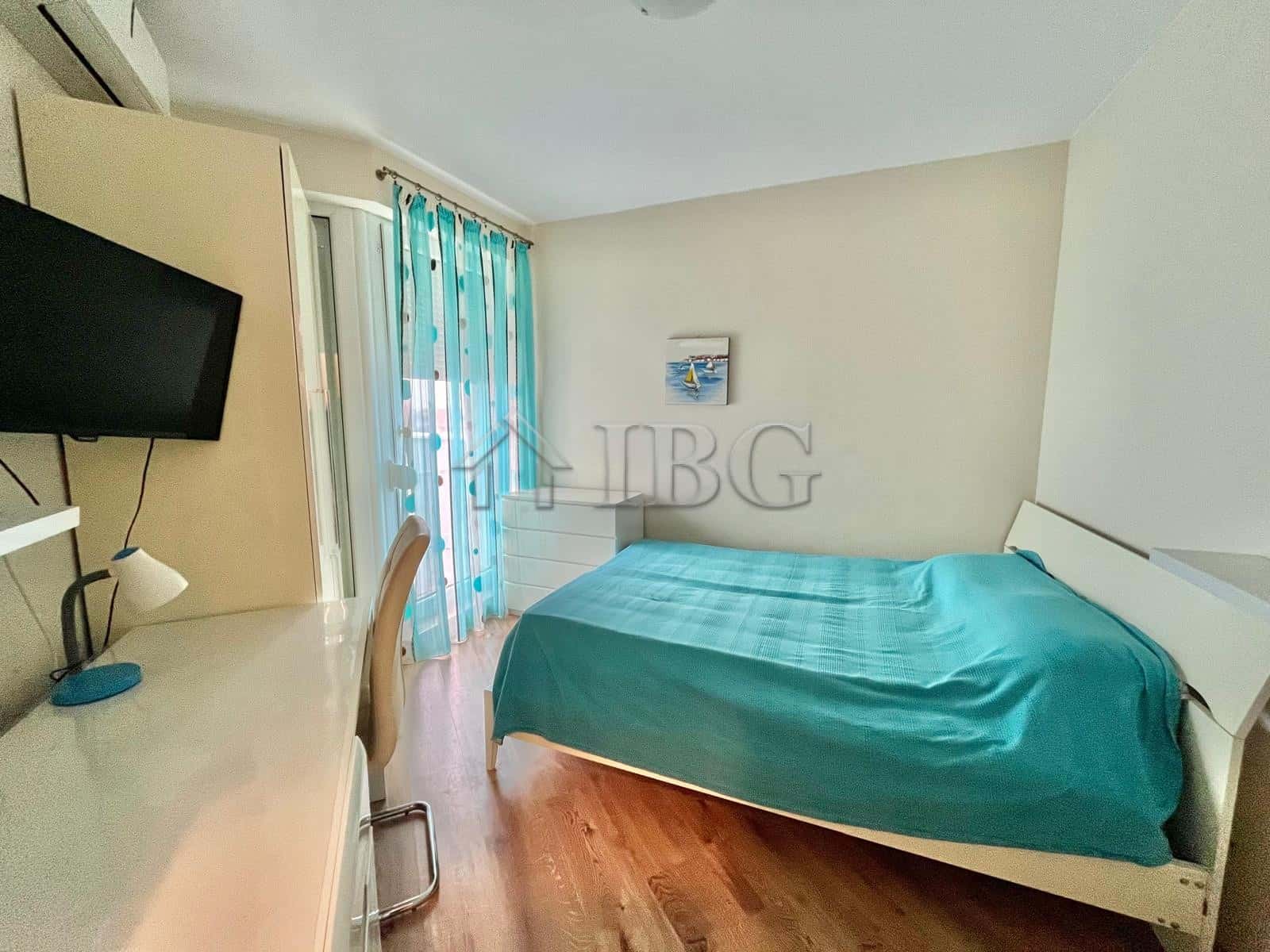 Cozy bedroom featuring a large bed, sea view, and balcony access in Ravda, Bulgaria. Perfect for rel.