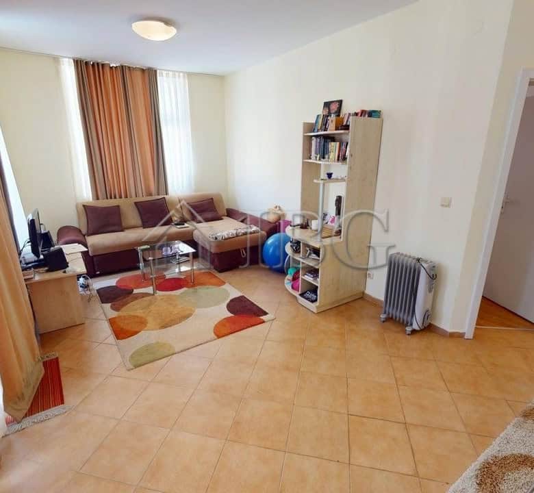 Bright living room with comfortable seating and large windows in Barco Del Sol complex.