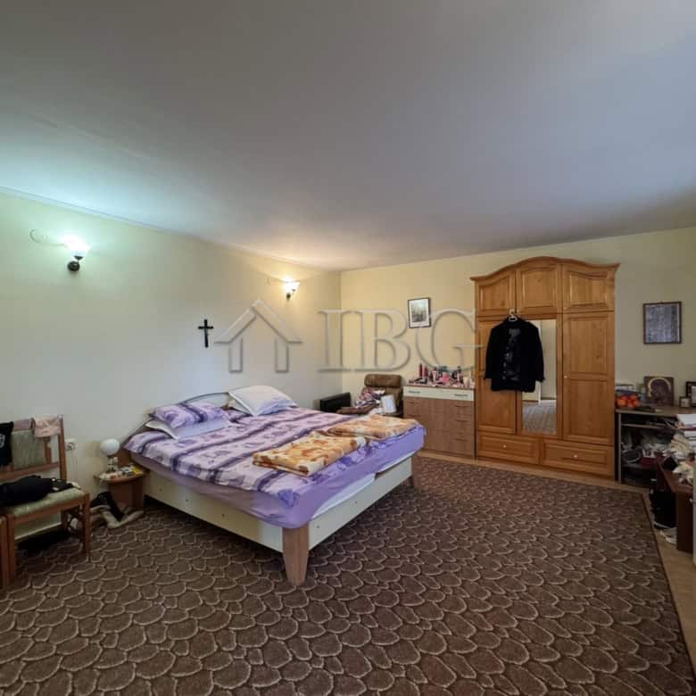 Bright bedroom with large bed and wooden wardrobe in Kosharitsa property.