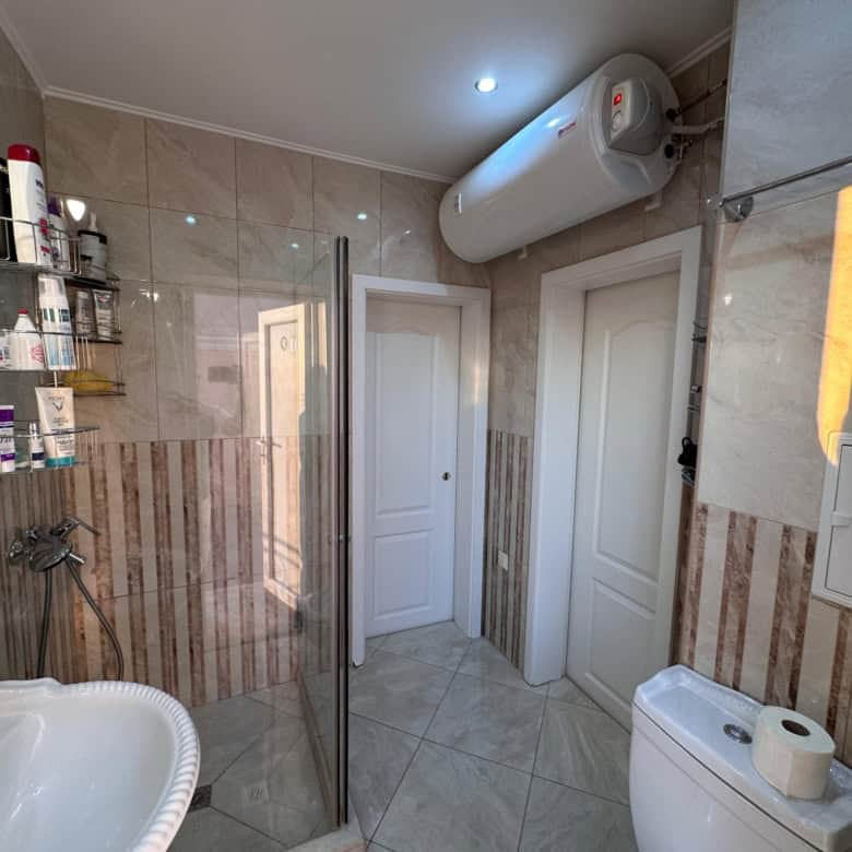 Bathroom with shower, toiletries, and water heater.