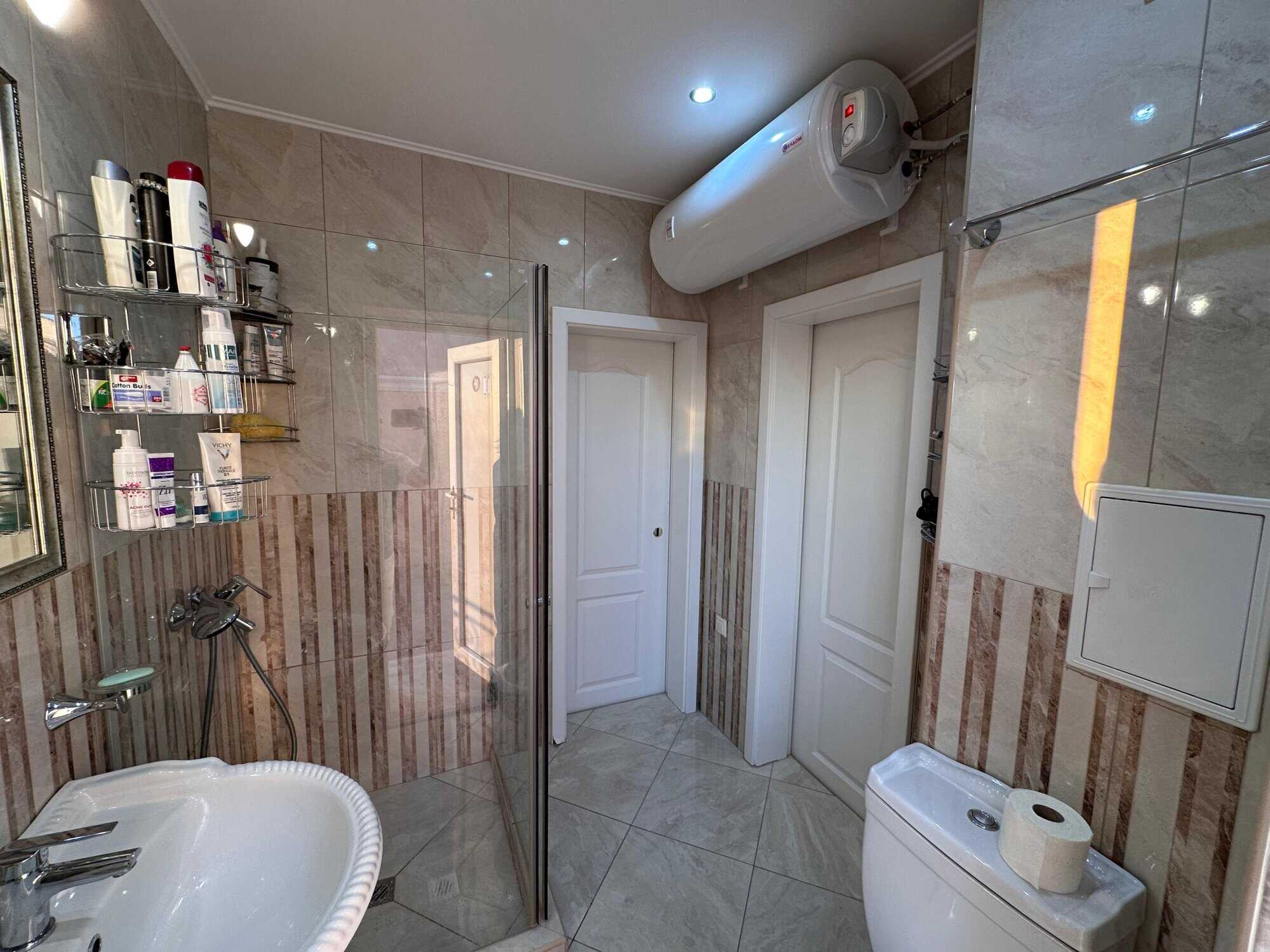 Bathroom with shower, toiletries, and water heater.