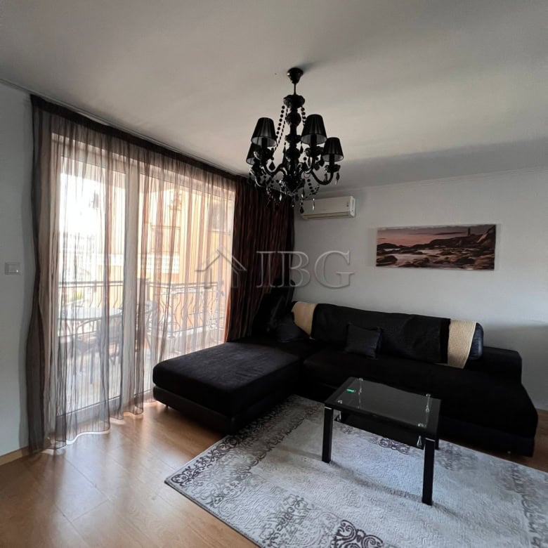 Modern living room with black sofa, chandelier, and panoramic sea views in Sveti Vlas apartment.