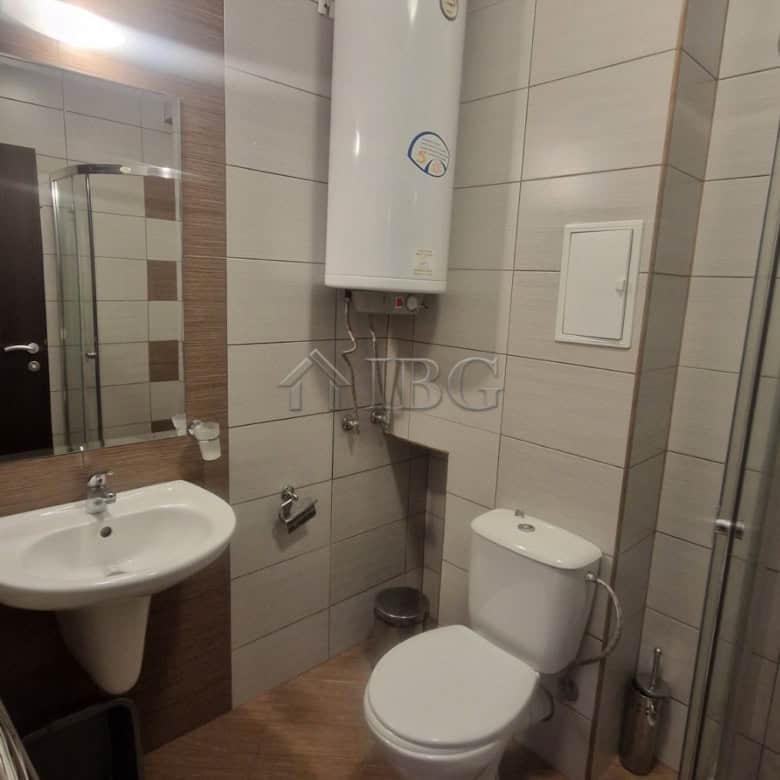 Bathroom with water heater, toilet, and sink in a modern apartment.