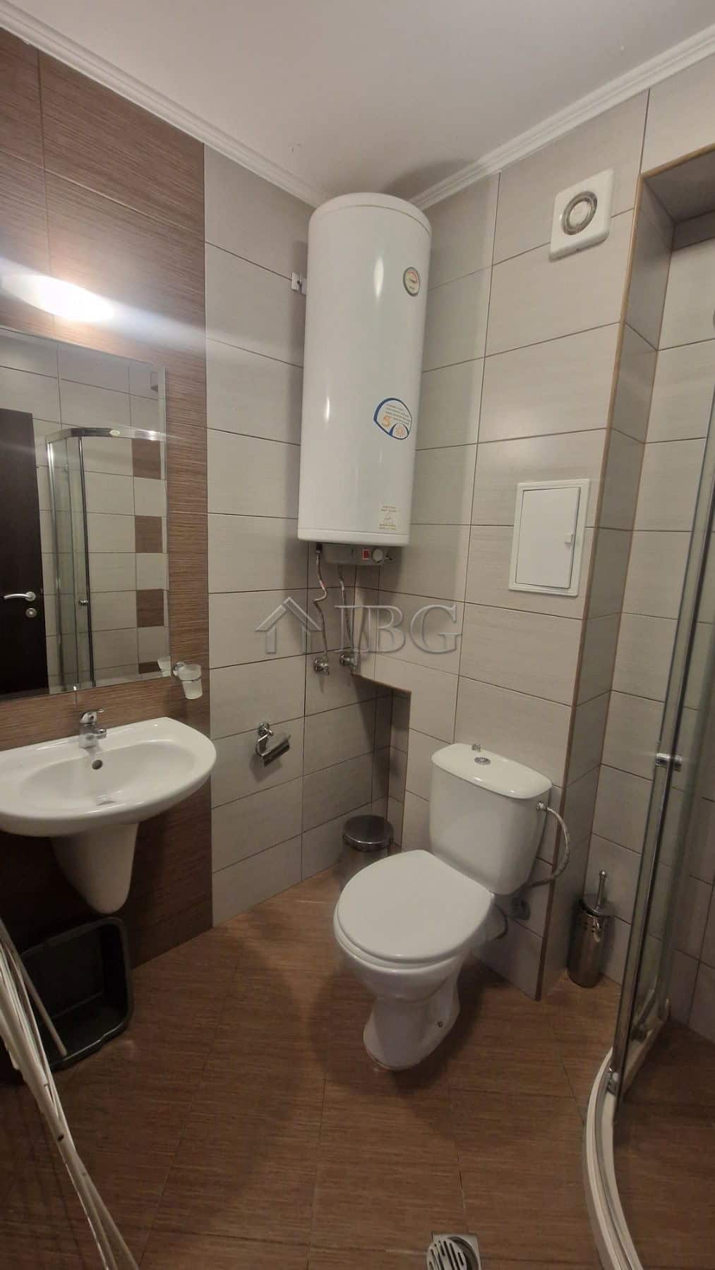 Bathroom with water heater, toilet, and sink in a modern apartment.