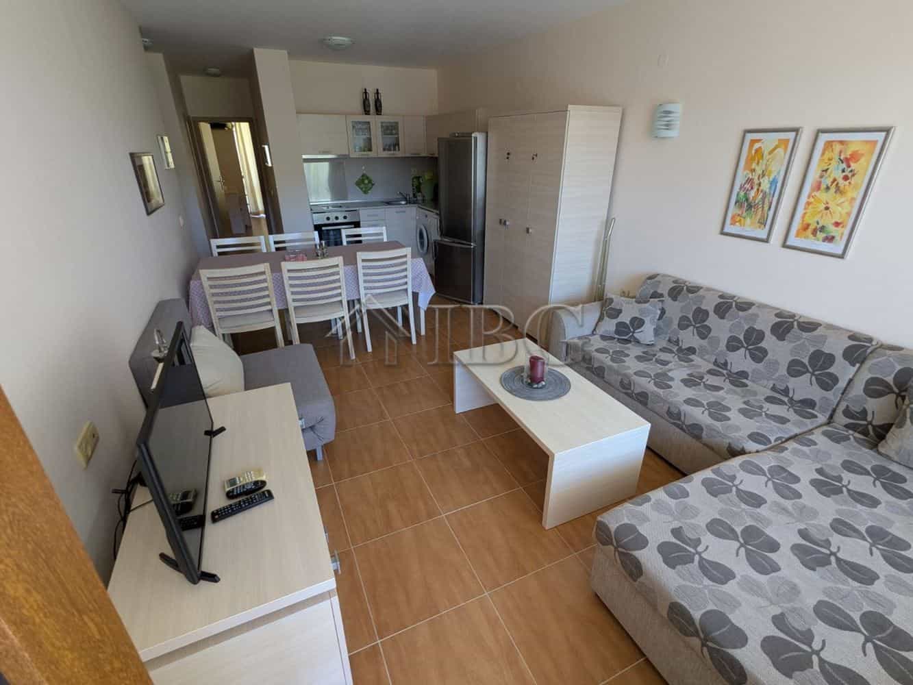 Spacious living room with sofa, TV, and open-plan kitchen in Sveti Vlas.