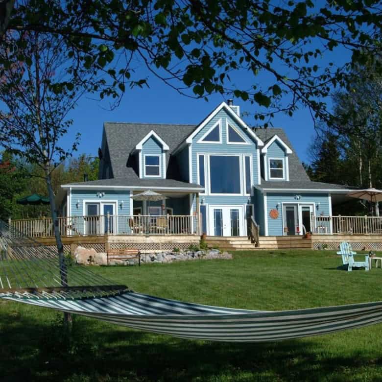 Beautiful ocean view manor with spacious deck and lush garden in Nova Scotia.