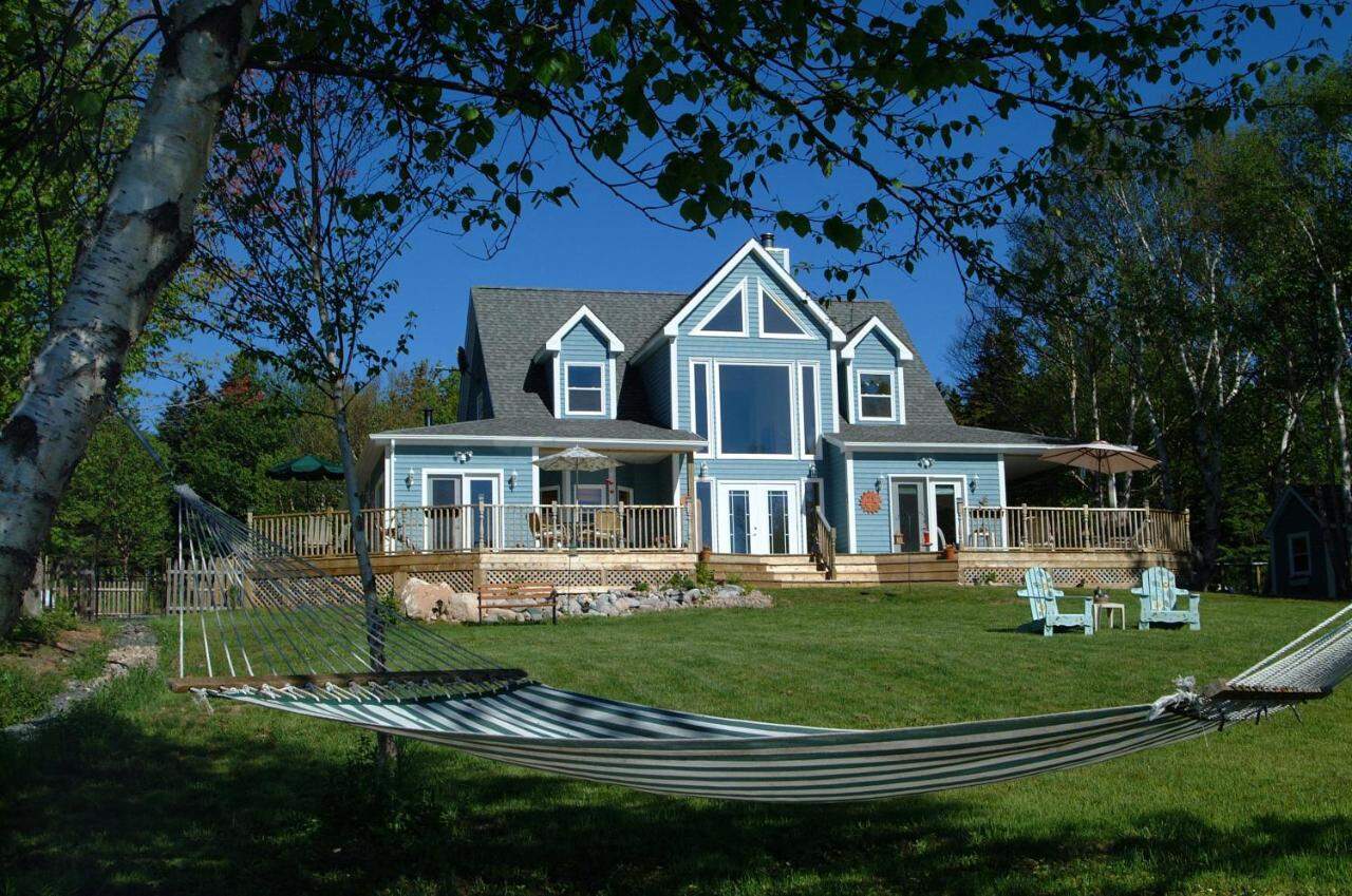 Beautiful ocean view manor with spacious deck and lush garden in Nova Scotia.
