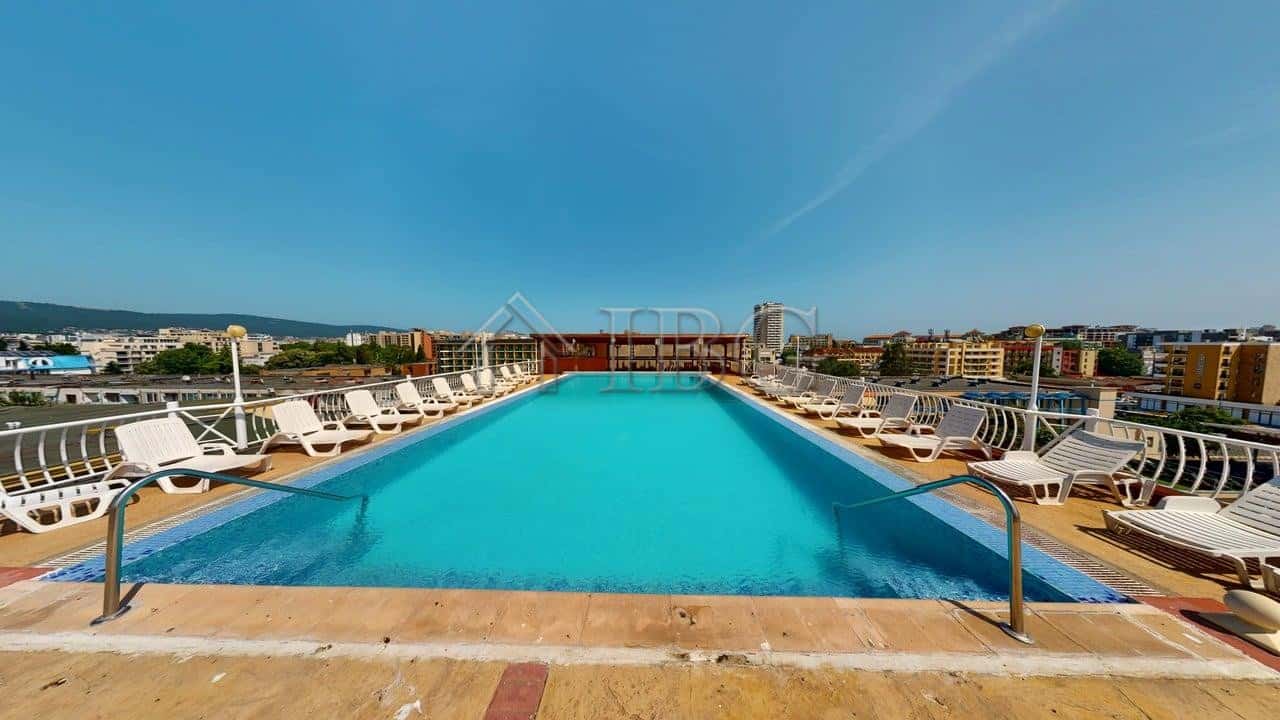 Pool at Barco Del Sol Complex in Sunny Beach, Bulgaria with sun loungers and city view.