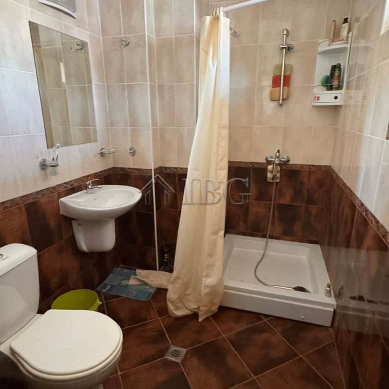 Bathroom with shower, toilet, and sink in a modern Sveti Vlas apartment.