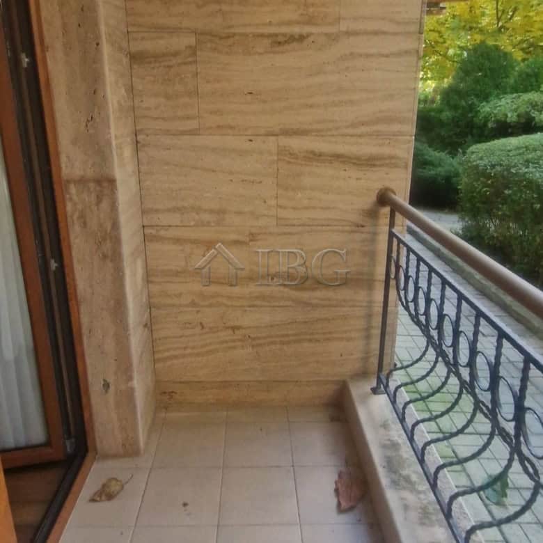 Cozy balcony of a one-bedroom apartment overlooking lush greenery in Sunny Beach.