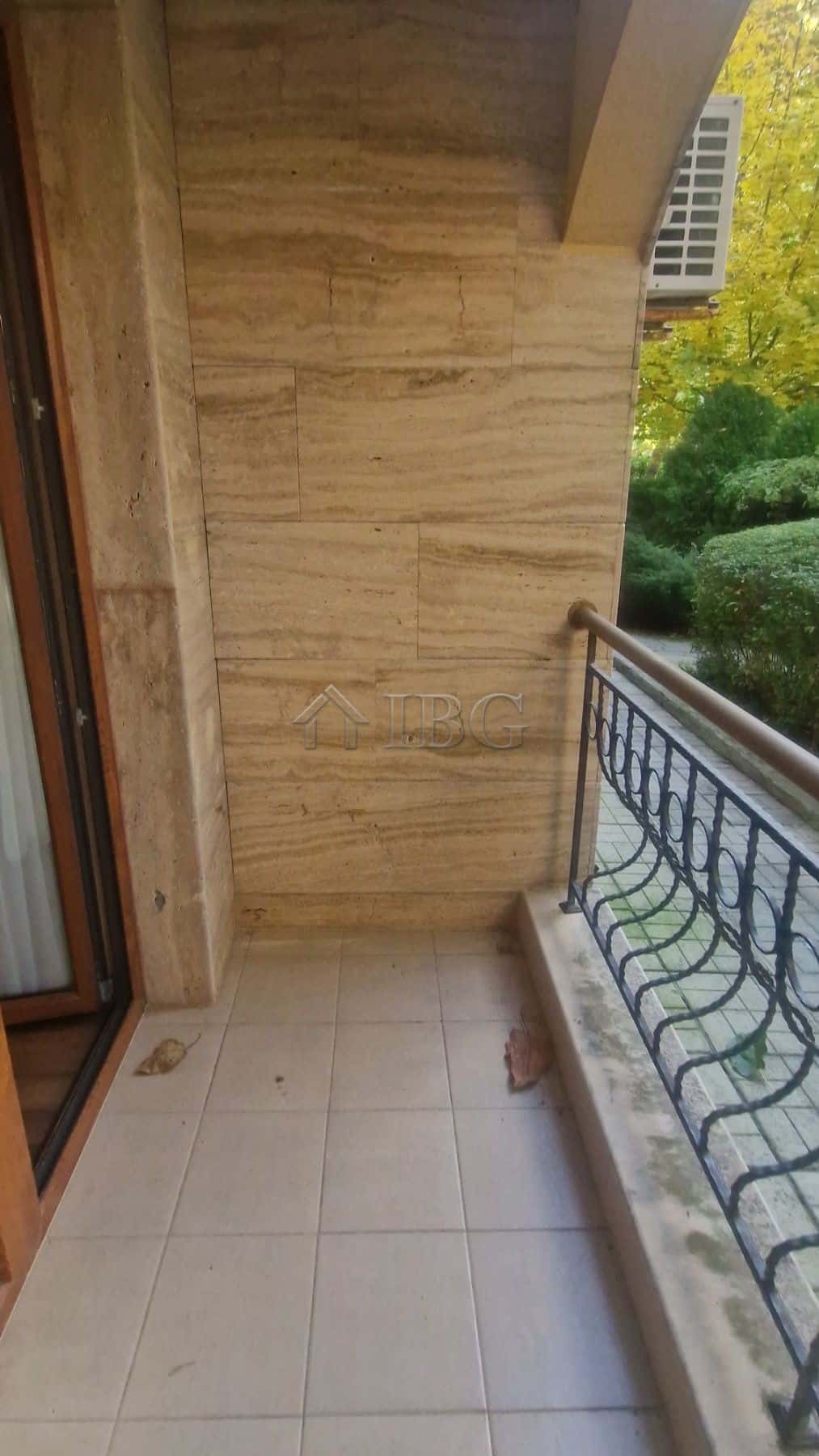 Cozy balcony of a one-bedroom apartment overlooking lush greenery in Sunny Beach.