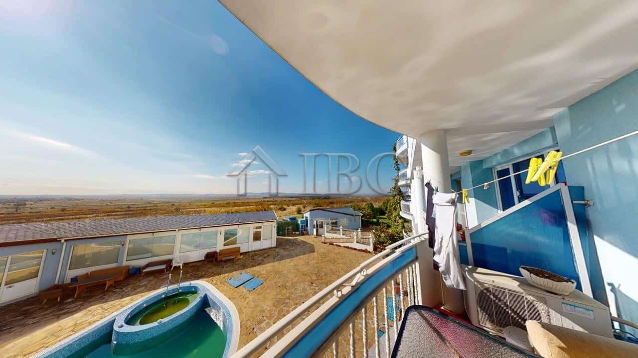 Modern apartment balcony overlooking pool and sea in Kosharitsa, Bulgaria.