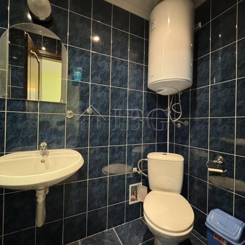 Bright bathroom with modern fixtures and dark tiled walls in Kosharitsa property.