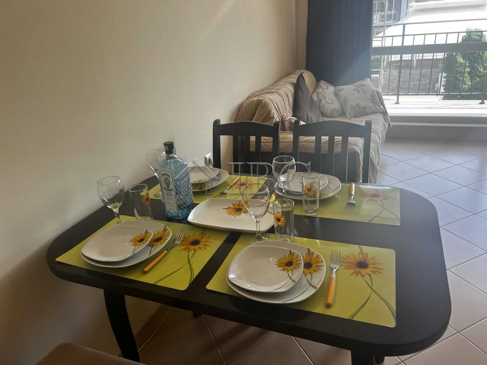 Bright dining area with table set for four, overlooking pool and balcony in Sunset Beach 3.