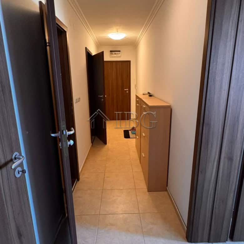 Bright hallway in Sveti Vlas apartment with wooden doors and ceiling lighting.