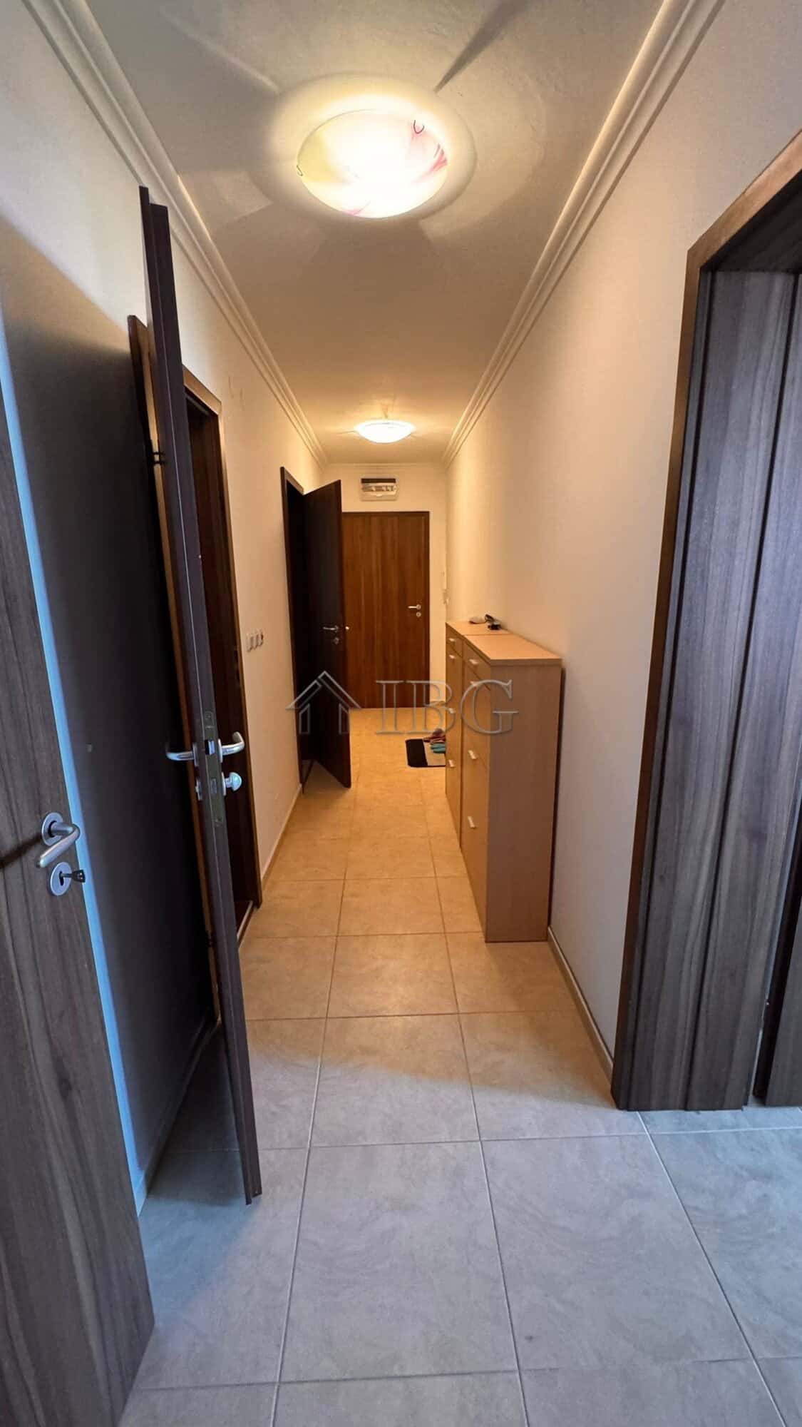 Bright hallway in Sveti Vlas apartment with wooden doors and ceiling lighting.