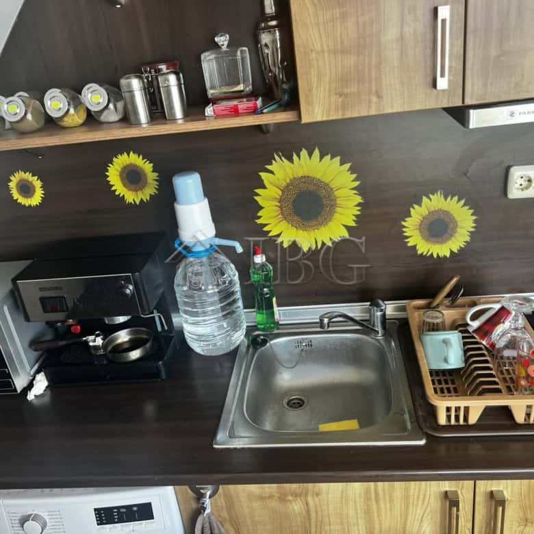 Bright kitchen featuring sunflower wall decals and modern appliances in Ravda property.