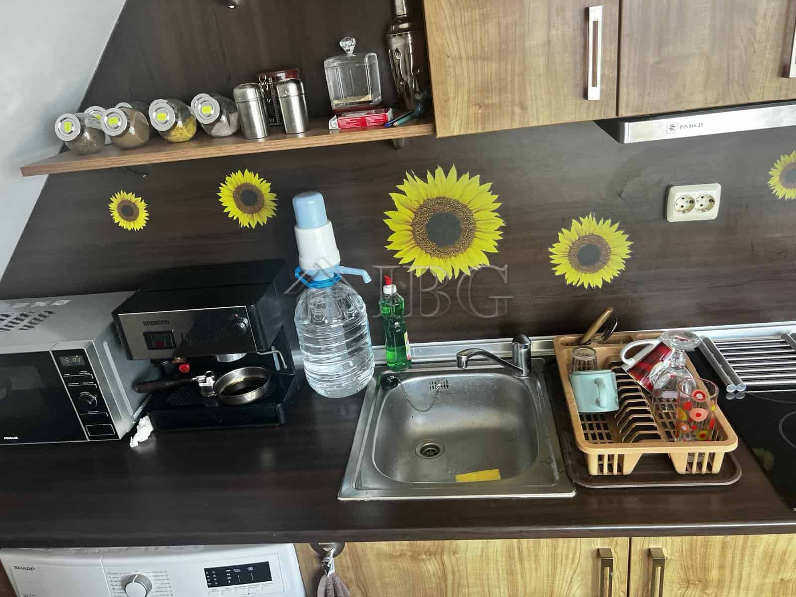 Bright kitchen featuring sunflower wall decals and modern appliances in Ravda property.