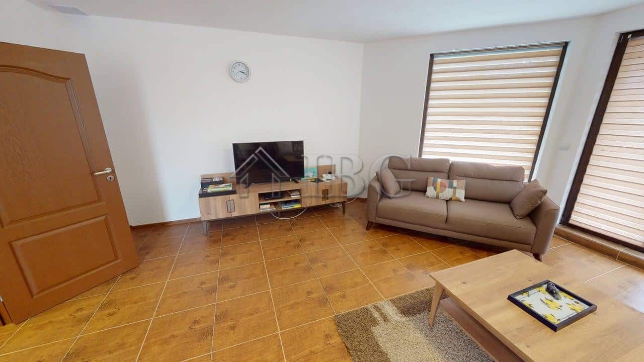 Bright living room with sofa and TV in Bay View Villas, Kosharitsa.