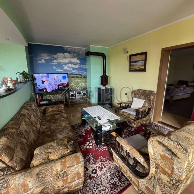 Spacious living area with comfortable sofas, a TV, and colorful decor in a four-story house in Kosha.