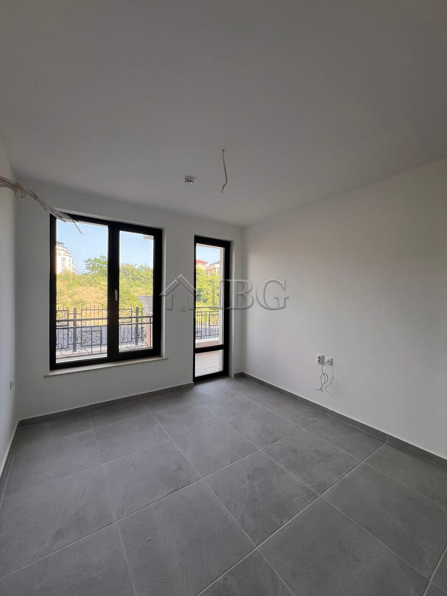 Bright empty room with large windows in Sveti Vlas apartment.