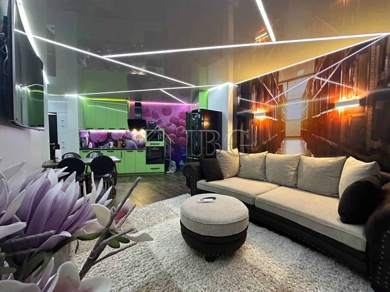 Stylish living room featuring contemporary furniture, colorful lighting, and a cozy atmosphere for r.