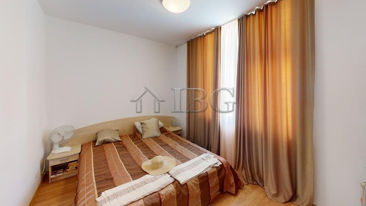 Bright 2-bedroom apartment with large windows and curtains in Sunny Beach.