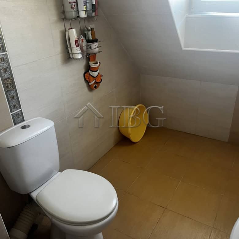 Clean and bright bathroom with toilet and decorative elements in a seaside apartment in Ravda.