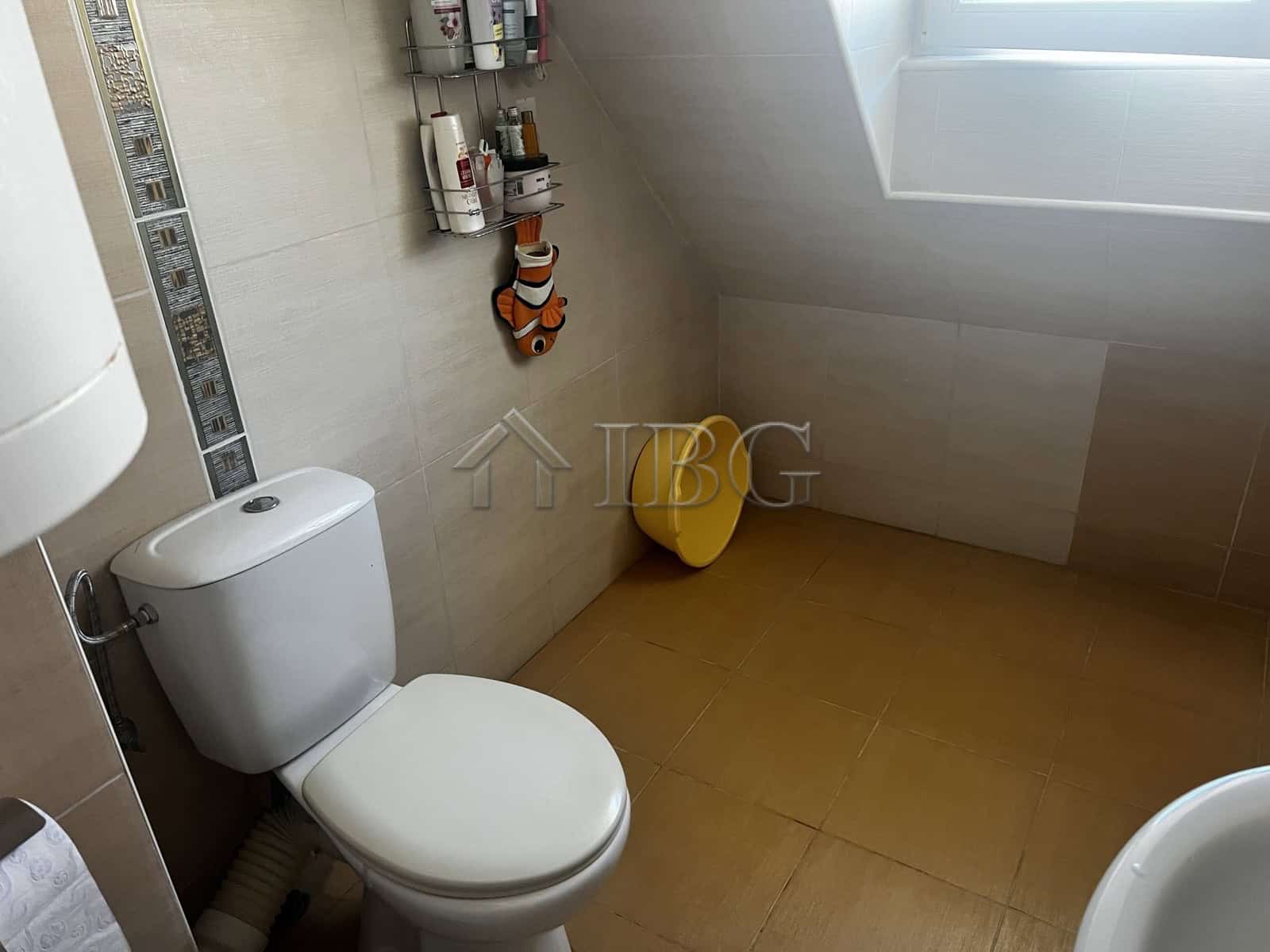 Clean and bright bathroom with toilet and decorative elements in a seaside apartment in Ravda.