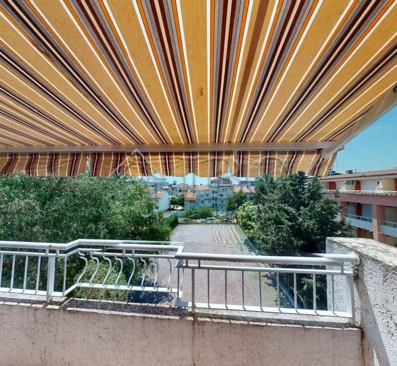Balcony view of the Sunny Fort complex in Sunny Beach, Bulgaria, with vibrant striped awning and lus.
