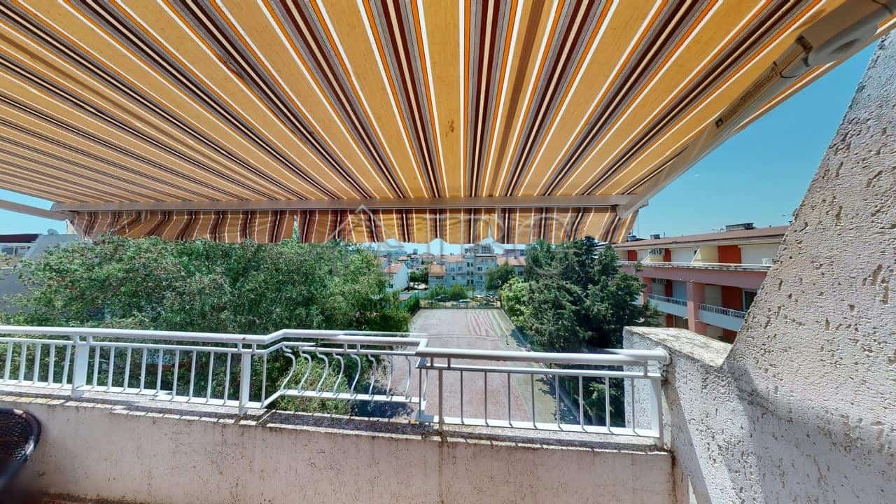 Balcony view of the Sunny Fort complex in Sunny Beach, Bulgaria, with vibrant striped awning and lus.