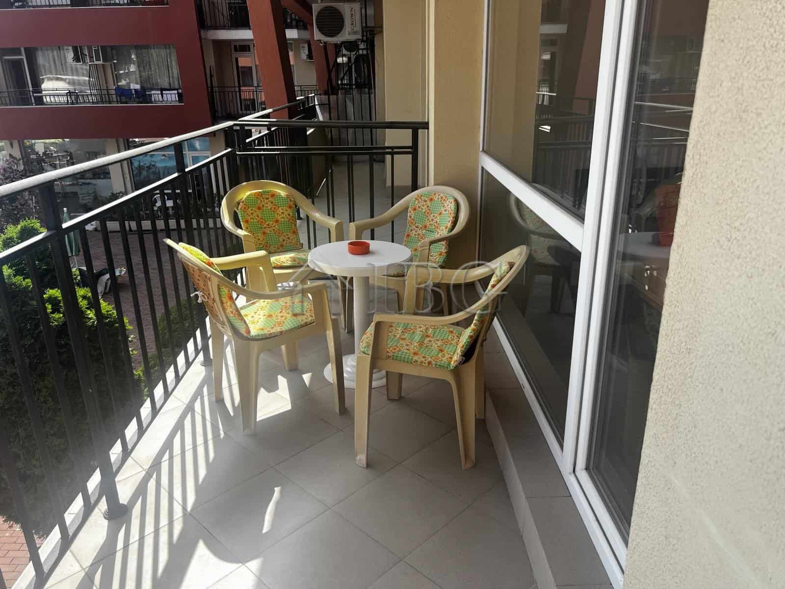 Balcony with outdoor seating overlooking pool in Sunset Beach 3, Sunny Beach.