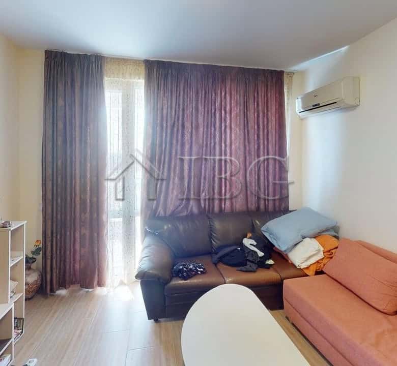 Bright living room with pool view in Kosharitsa apartment, featuring comfortable seating and modern.