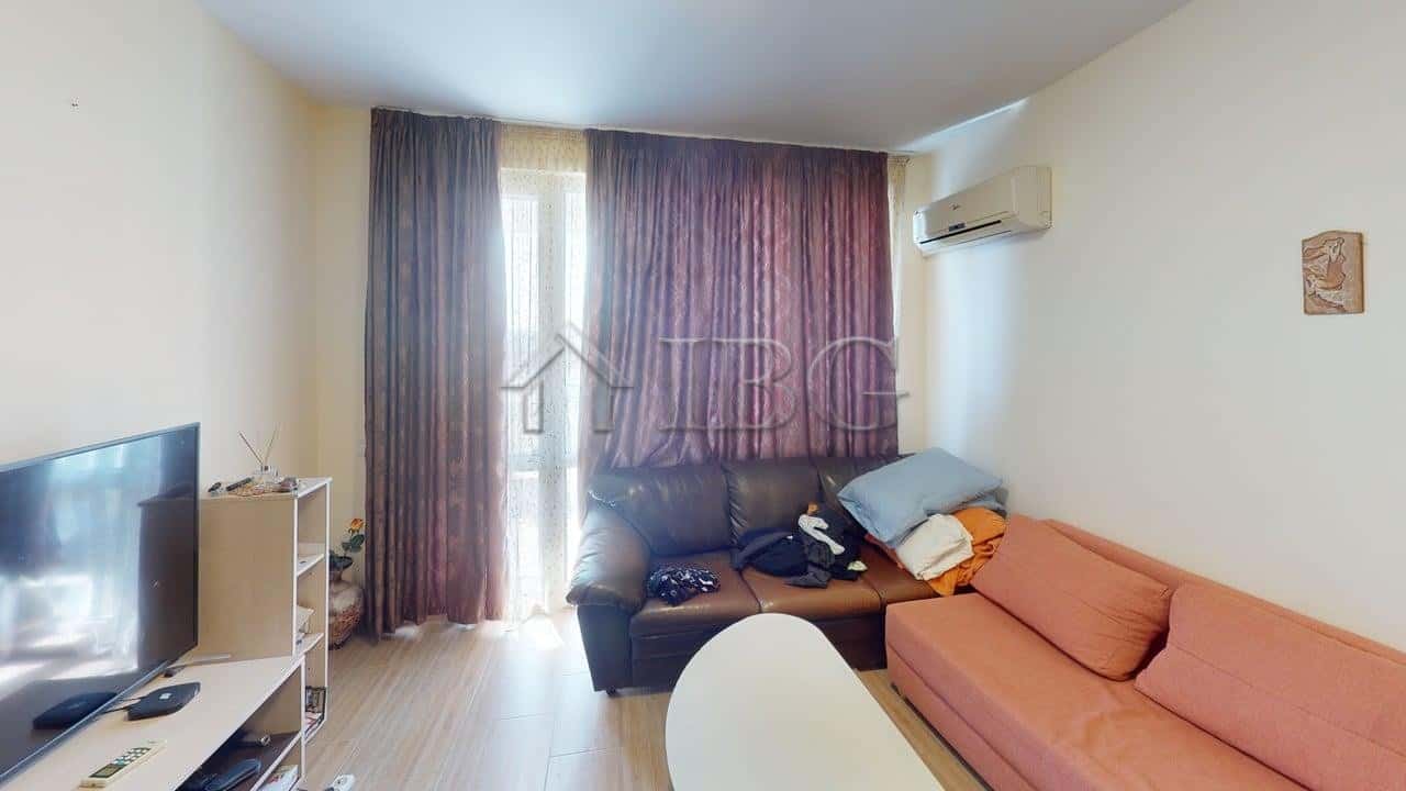 Bright living room with pool view in Kosharitsa apartment, featuring comfortable seating and modern.