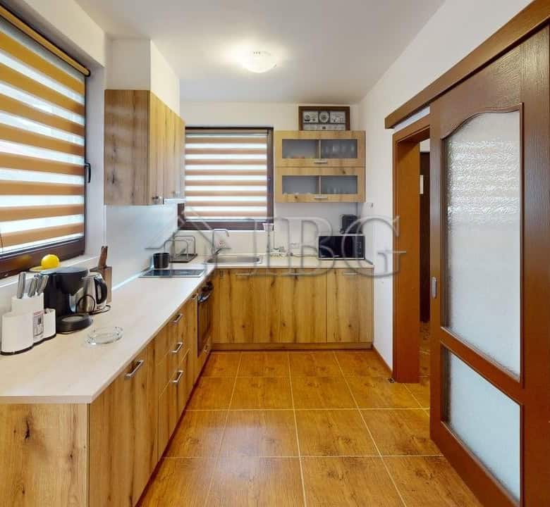 Bright kitchen with wooden cabinets and modern appliances in a Kosharitsa maisonette.