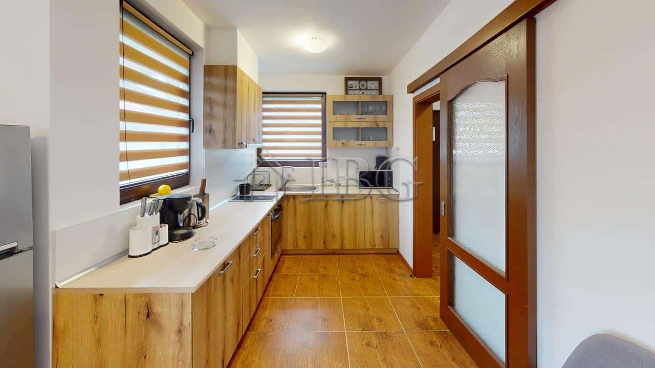 Bright kitchen with wooden cabinets and modern appliances in a Kosharitsa maisonette.
