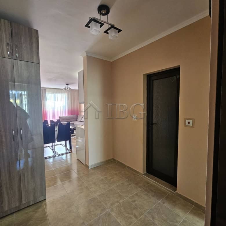 Spacious entrance hall of a 2-bedroom apartment with neutral decor and tiled flooring in Villa Kater.