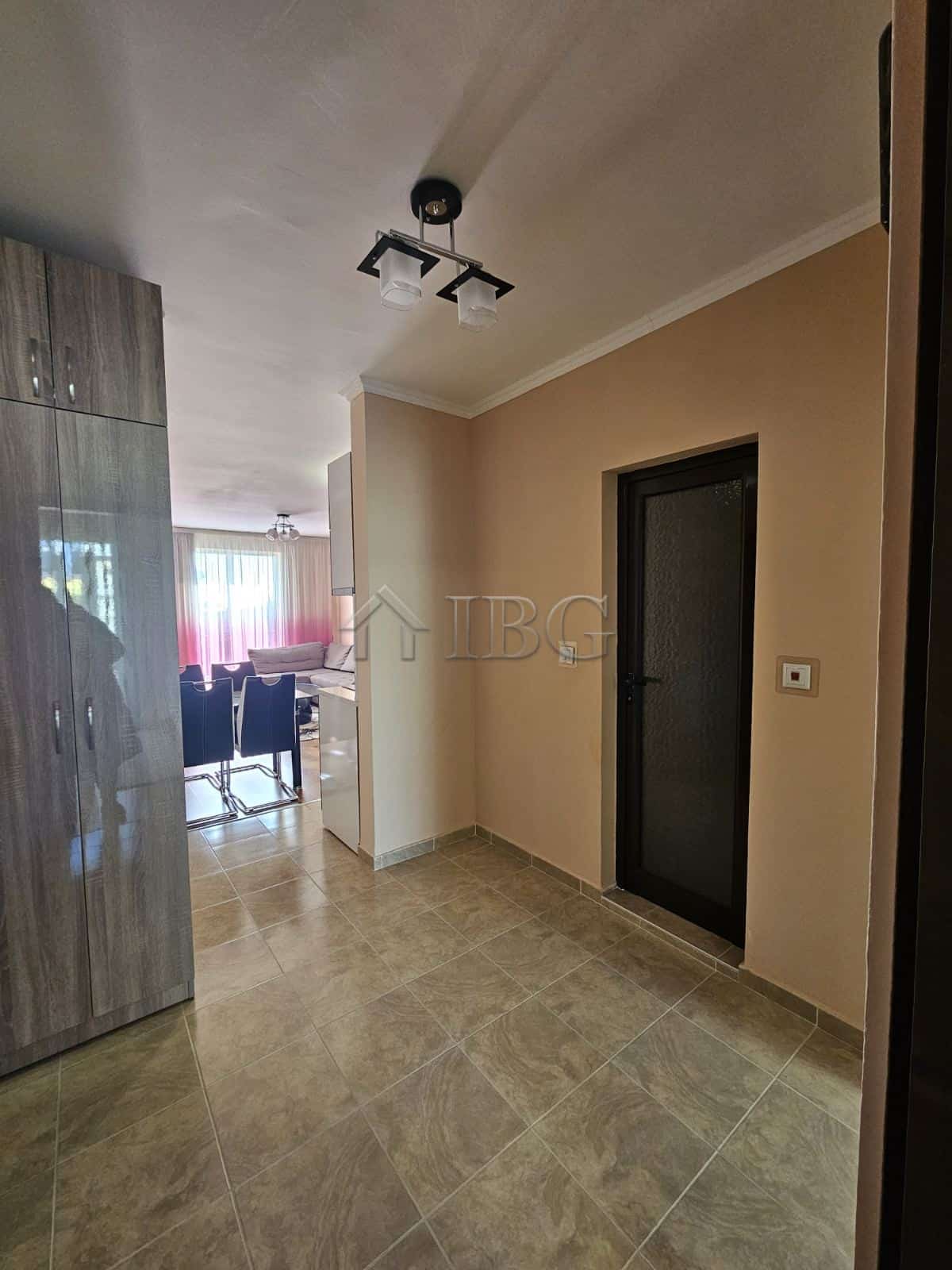 Spacious entrance hall of a 2-bedroom apartment with neutral decor and tiled flooring in Villa Kater.
