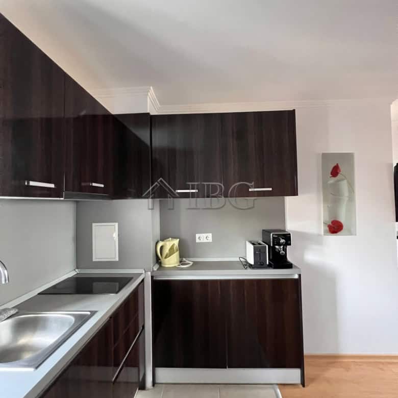 Modern kitchen with dark cabinetry and white countertops in Sveti Vlas apartment.