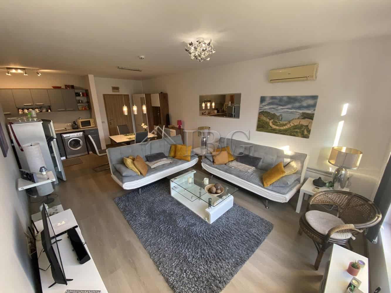 Bright living room with comfortable sofas and scenic mountain view.