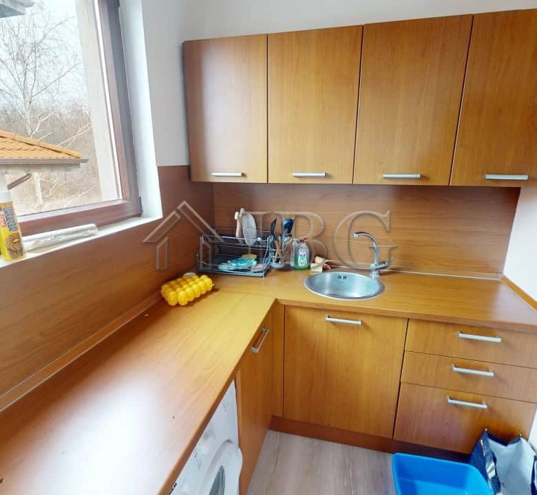 Bright and functional kitchen with wooden cabinets and appliances in Bay View Villas, Kosharitsa.