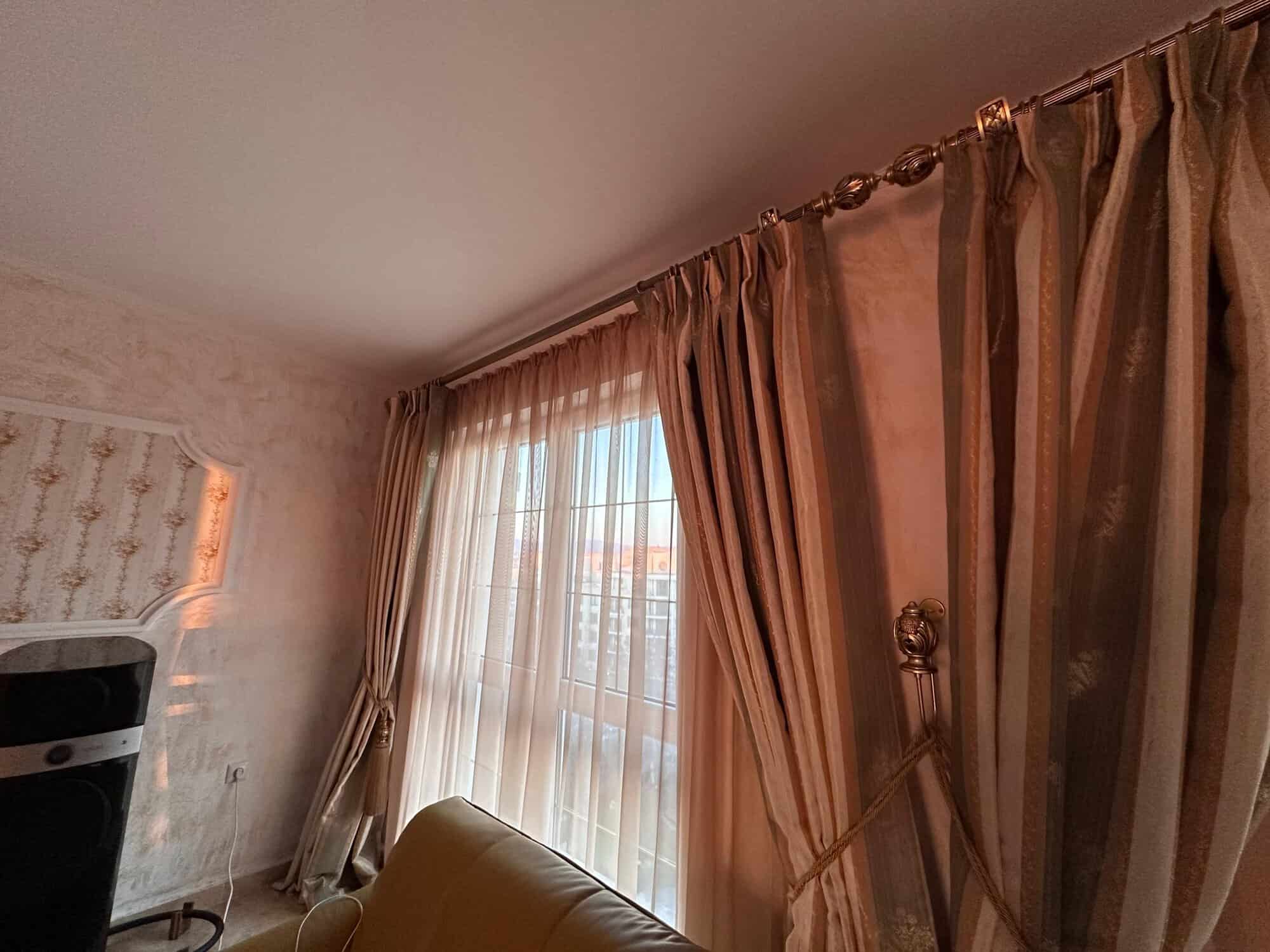 Bright living room with large windows and elegant curtains in Venera Palace, Sunny Beach.