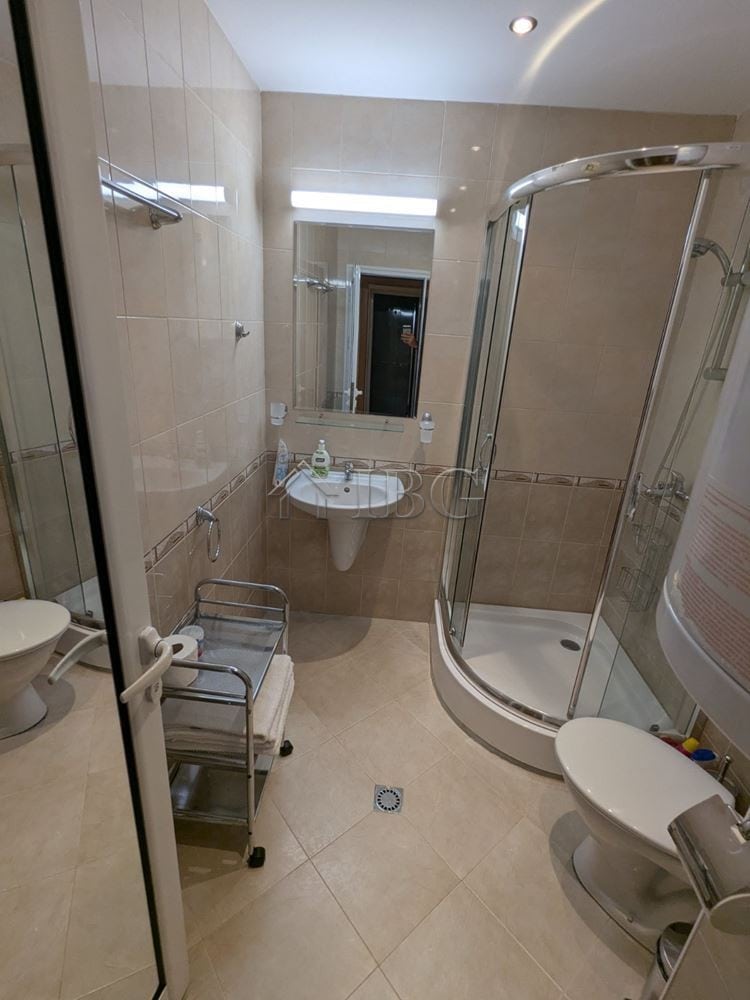 Bathroom with shower, toilet, and sink in Sveti Vlas apartment with modern fixtures.