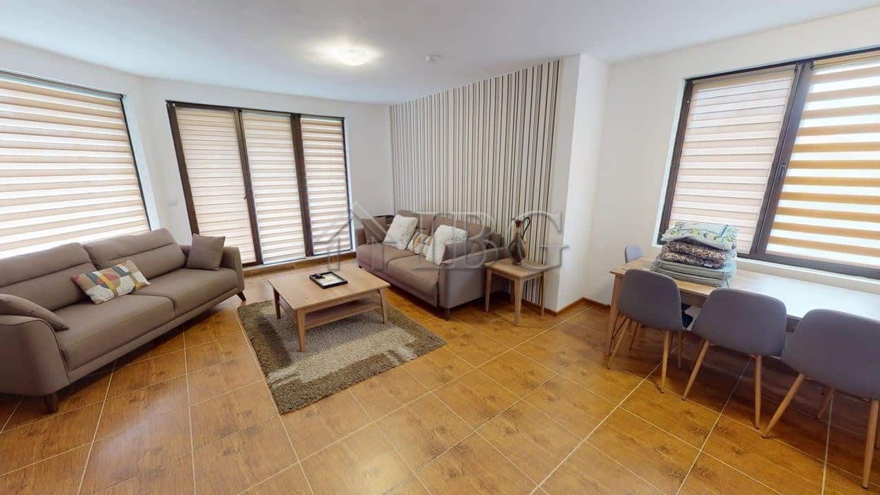 Spacious living room with large windows and cozy sofas in Bay View Villas, Kosharitsa.