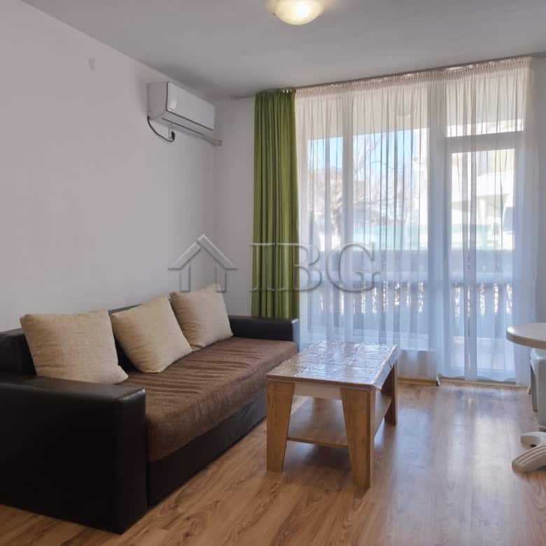 Cozy living room with sofa, coffee table, and large windows in Chateau Aheloy 2.